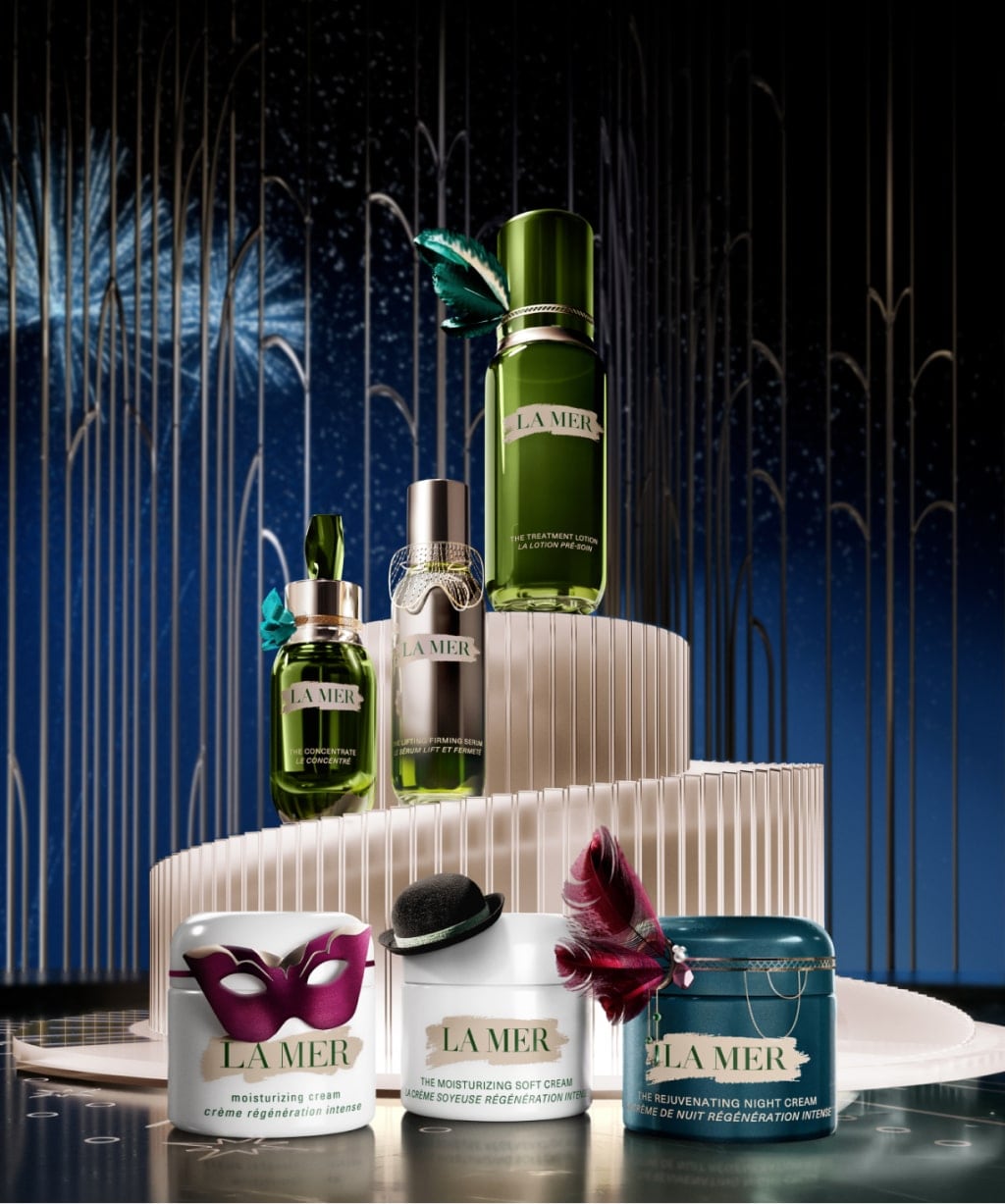 Selection of La Mer bestsellers, decorated in festive attire, in a grand setting with fireworks in the night sky beyhind