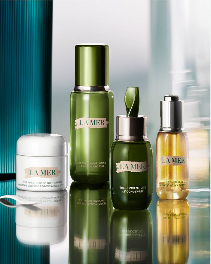 Photograph of La Mer products set up on a glass Vanity with reflection.